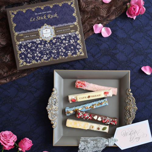 ブランドのアイコンである小花柄（バラ）をあしらい、<br>トレンドカラーのチョコレートブラウンでまとめたホワイトデー限定パッケージ。<br>甘さの中に品の良さを感じさせる、カフェオウザンらしい「大人可愛い」世界観を大切な方への贈りものに。